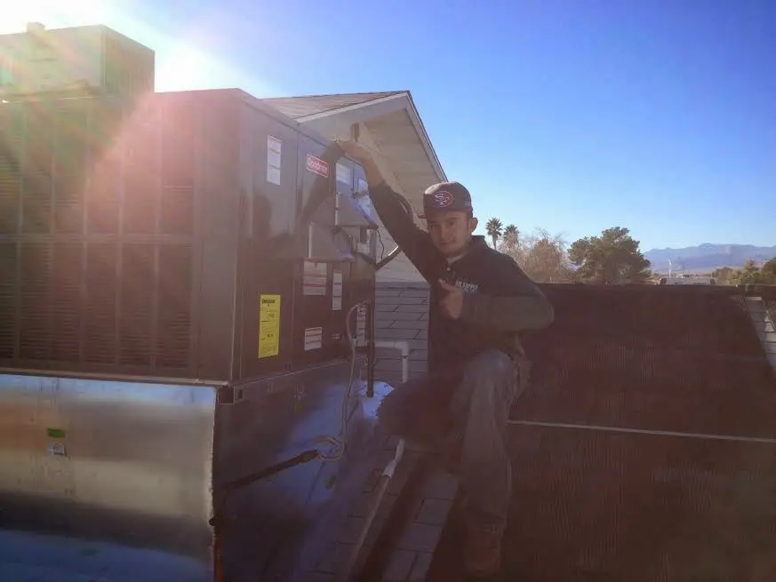 HVAC technician performing AC Tune-Up on a rooftop unit in Medford